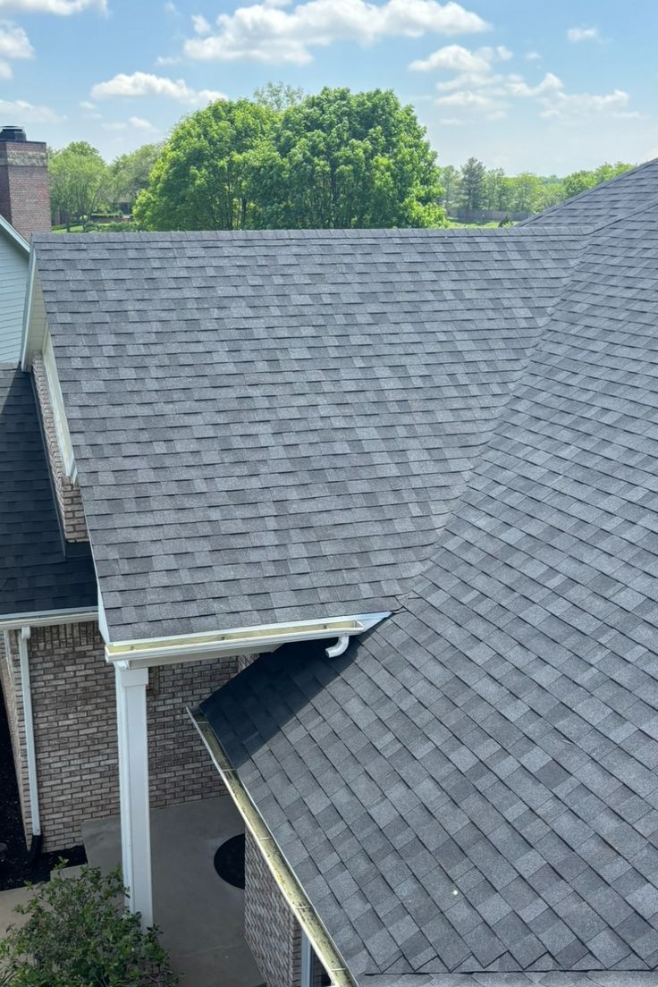 Newly replaced onyx architectural shingle roof planes on a two-story brick home after hail damage